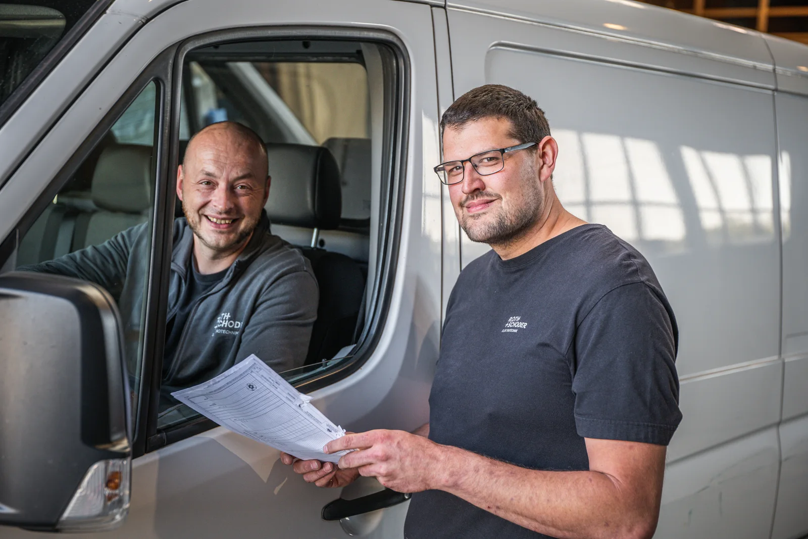 Zwei Kollegen von Roth und Schoder bei der Abstimmung am Servicefahrzeug
